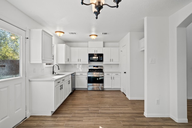 kitchen featuring tasteful backsplash, stainless steel appliances, sink, hardwood / wood-style flooring, and white cabinetry