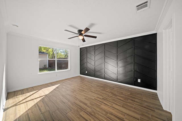 spare room with hardwood / wood-style floors, a textured ceiling, ceiling fan, and crown molding