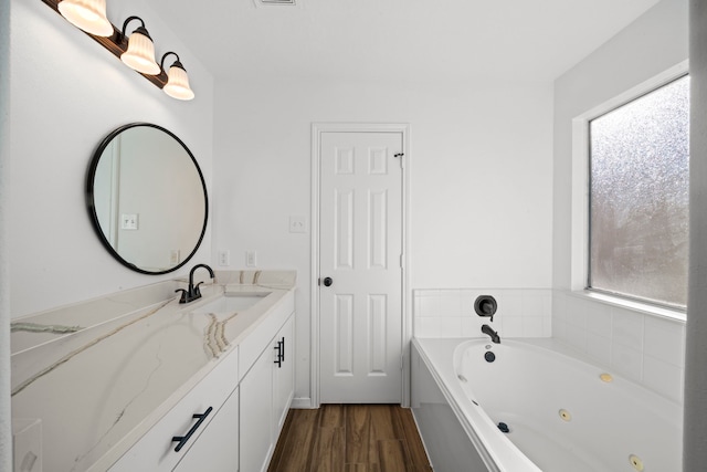 bathroom with a washtub, hardwood / wood-style floors, vanity, and a wealth of natural light