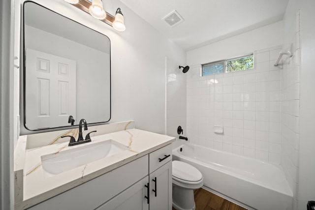 full bathroom featuring tiled shower / bath, toilet, vanity, and hardwood / wood-style flooring