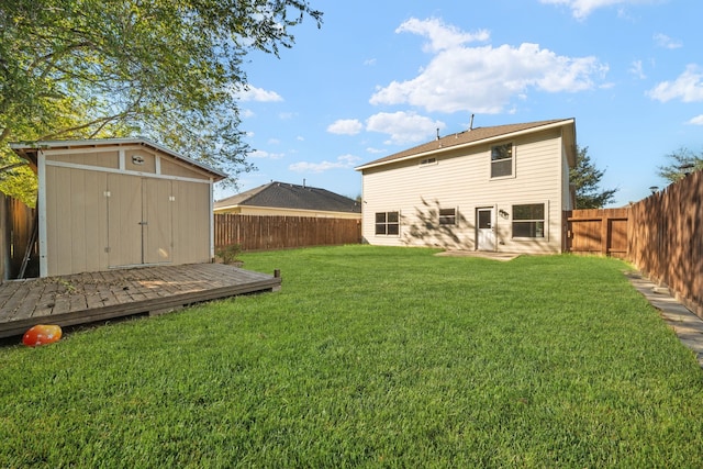 back of property with a wooden deck, a yard, and a shed