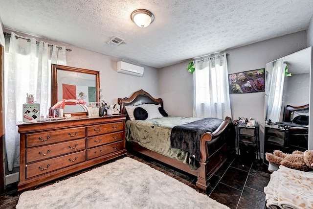 tiled bedroom featuring an AC wall unit and a textured ceiling