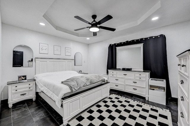 tiled bedroom with a raised ceiling and ceiling fan