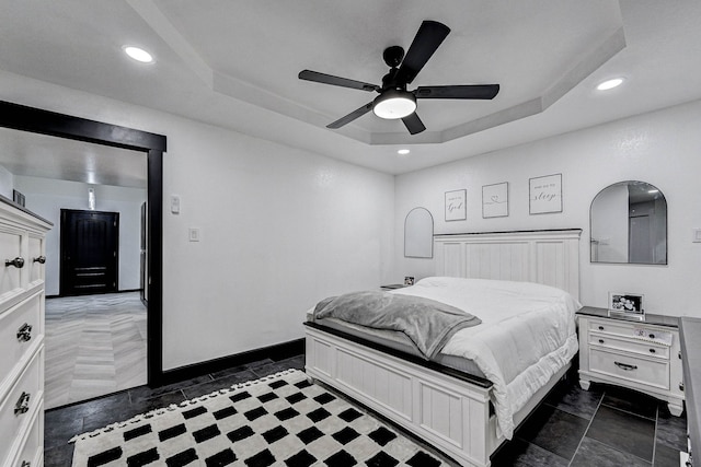 bedroom featuring a raised ceiling and ceiling fan