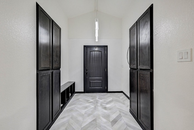 kitchen featuring decorative light fixtures, light parquet floors, and vaulted ceiling