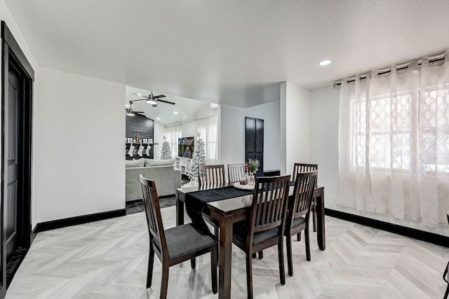 dining room with ceiling fan, light parquet floors, and a textured ceiling