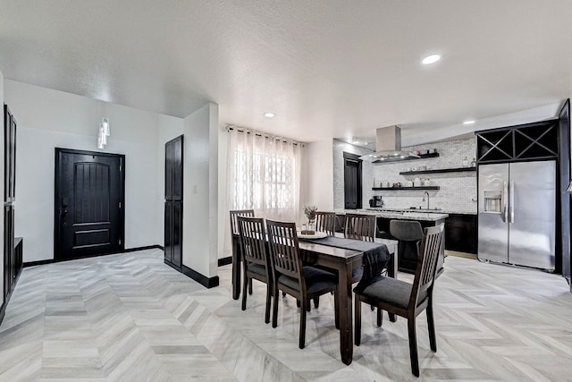 dining space featuring a textured ceiling, indoor bar, and light parquet flooring