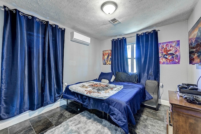 bedroom featuring a wall mounted AC and a textured ceiling