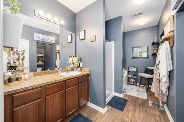 bathroom featuring hardwood / wood-style floors, vanity, and separate shower and tub