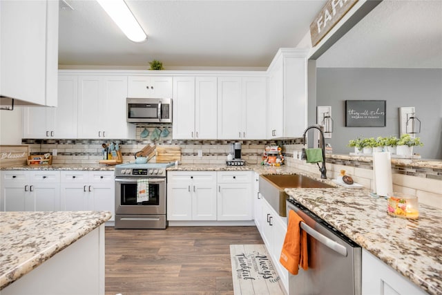 kitchen featuring stainless steel appliances, white cabinetry, dark wood-type flooring, and sink