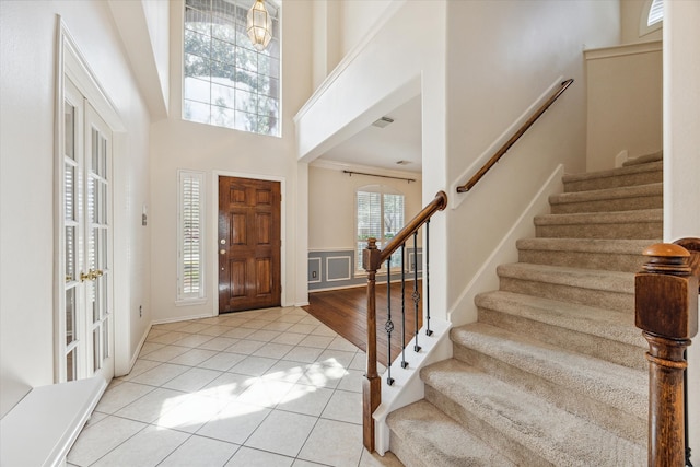 entrance foyer with light wood-type flooring and a towering ceiling