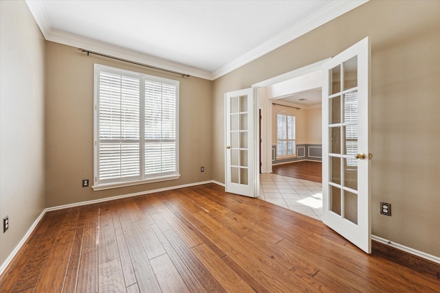 spare room featuring french doors, ornamental molding, and hardwood / wood-style flooring