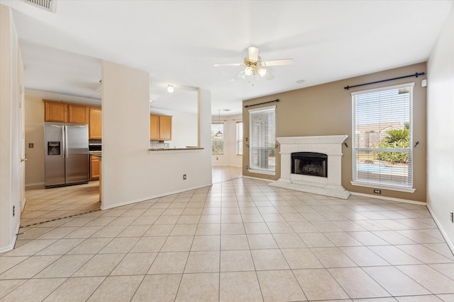 unfurnished living room with ceiling fan and light tile patterned floors