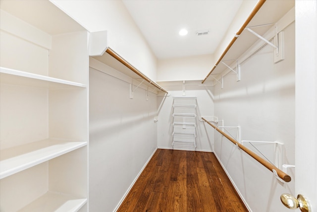 spacious closet with dark hardwood / wood-style flooring