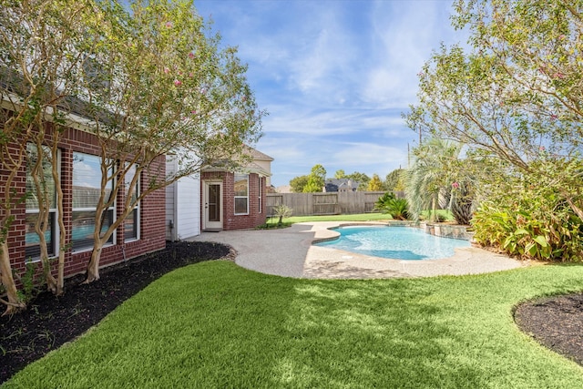 view of pool with a lawn and a patio