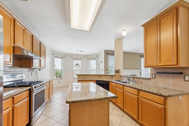 kitchen featuring stainless steel gas range oven, sink, tasteful backsplash, a kitchen island, and kitchen peninsula