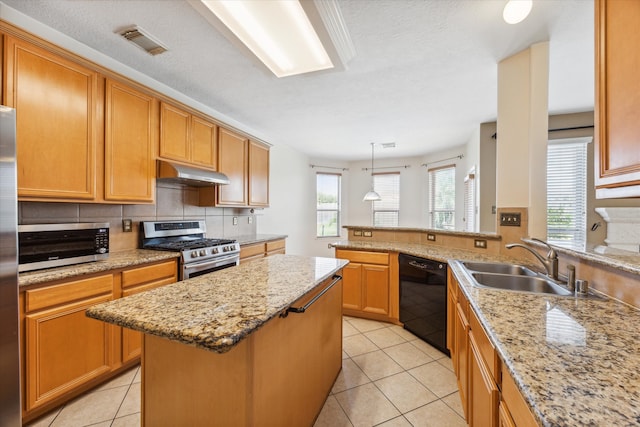 kitchen featuring plenty of natural light, a kitchen island, sink, and appliances with stainless steel finishes