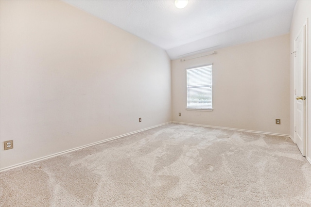 carpeted spare room featuring lofted ceiling