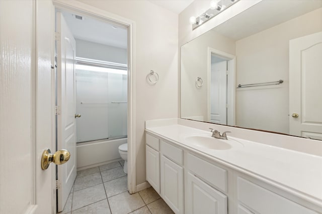 full bathroom with tile patterned floors, vanity, bath / shower combo with glass door, and toilet