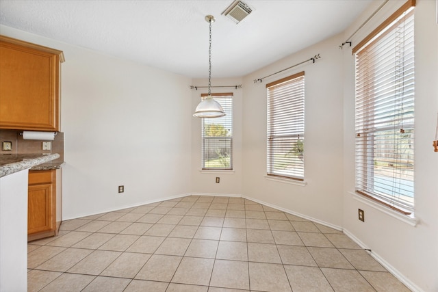 unfurnished dining area featuring light tile patterned floors