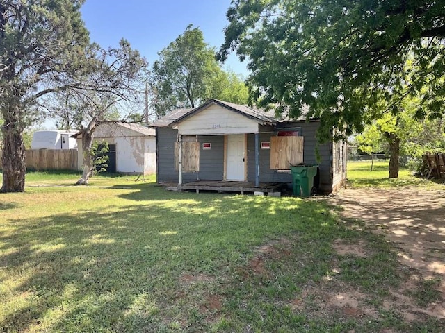 view of front of home featuring an outdoor structure and a front yard