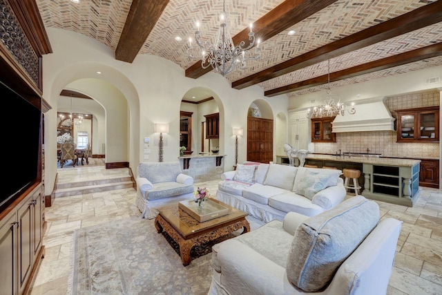 living room with beamed ceiling, brick ceiling, and a chandelier