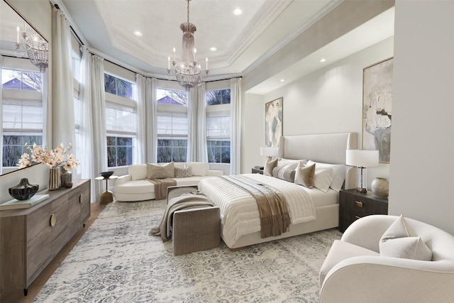 bedroom with a raised ceiling, ornamental molding, a chandelier, and light hardwood / wood-style flooring