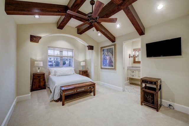 bedroom featuring connected bathroom, vaulted ceiling with beams, light colored carpet, and ceiling fan