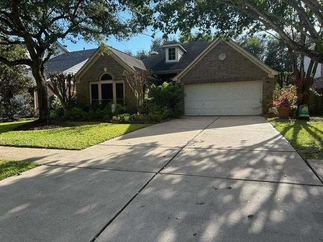 view of front of property with a garage and a front lawn