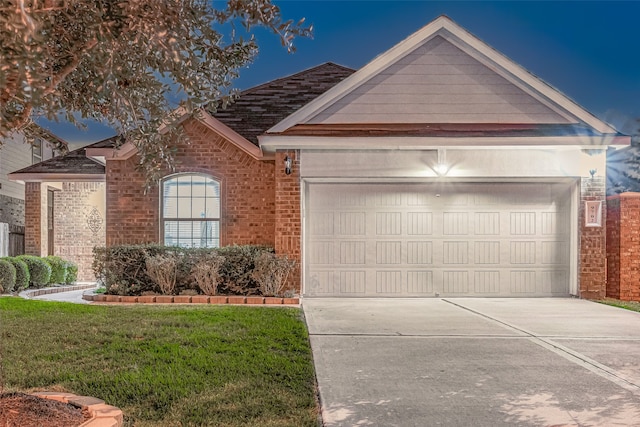 ranch-style house featuring a garage and a front lawn