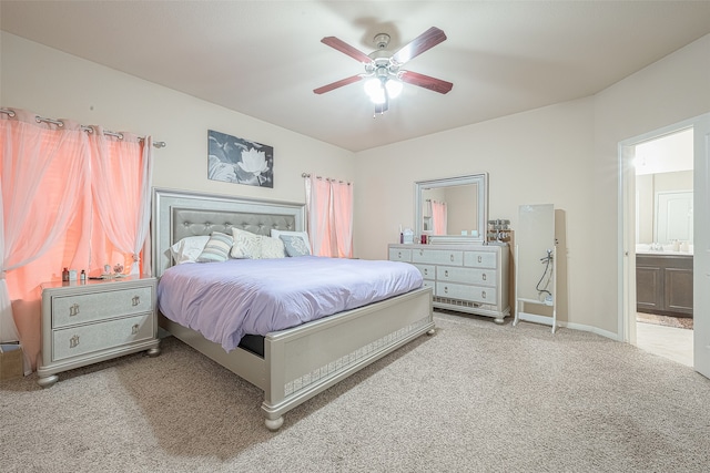 bedroom with connected bathroom, ceiling fan, and light carpet