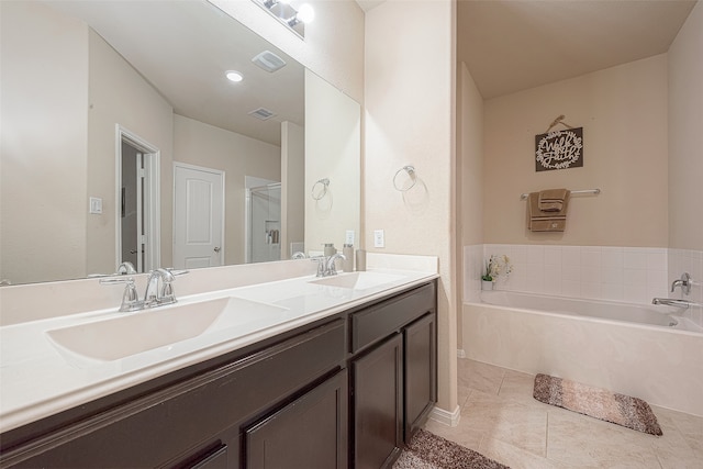 bathroom with tile patterned floors, a washtub, and vanity