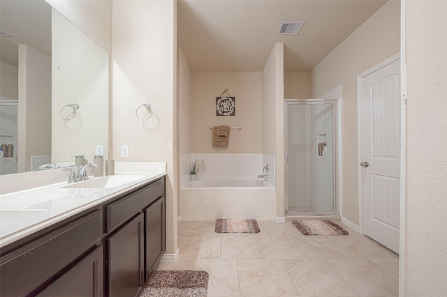 bathroom with tile patterned flooring, vanity, and shower with separate bathtub