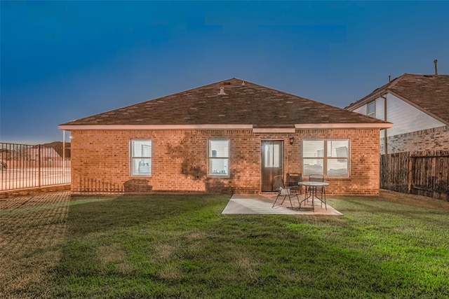 rear view of house featuring a patio area and a yard