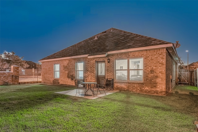 back of house featuring a lawn and a patio