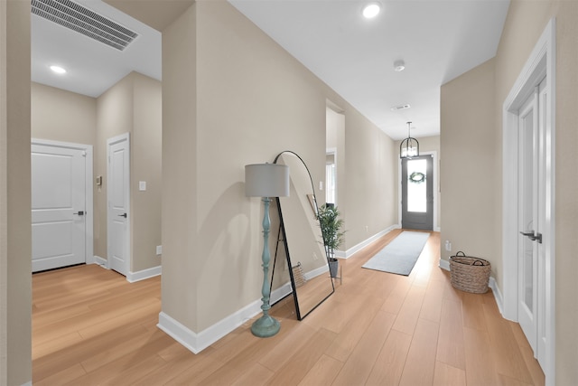 foyer entrance featuring hardwood / wood-style floors and a chandelier