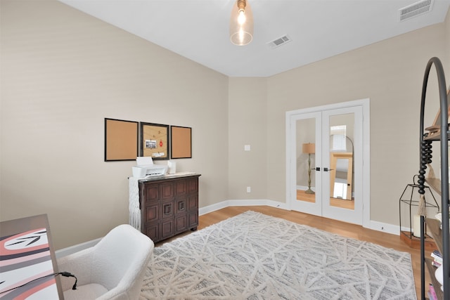 bedroom with french doors and light hardwood / wood-style flooring