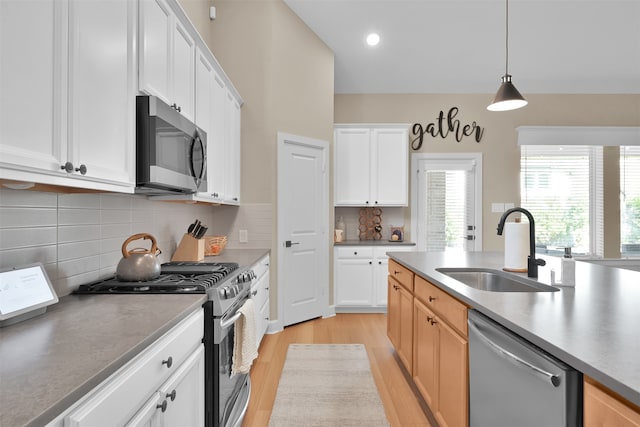 kitchen featuring light hardwood / wood-style flooring, stainless steel appliances, white cabinetry, and sink