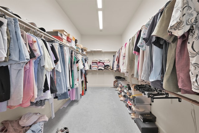 walk in closet featuring light colored carpet