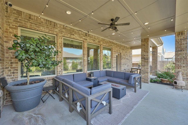 view of patio with ceiling fan and an outdoor living space with a fire pit