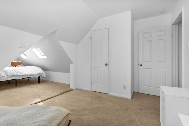 bedroom with lofted ceiling with skylight and light carpet