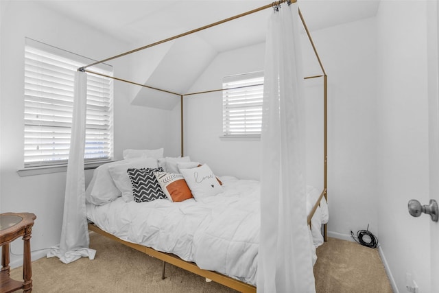 carpeted bedroom featuring lofted ceiling and multiple windows