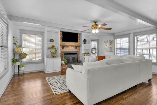 living room featuring ceiling fan, plenty of natural light, built in features, and a fireplace