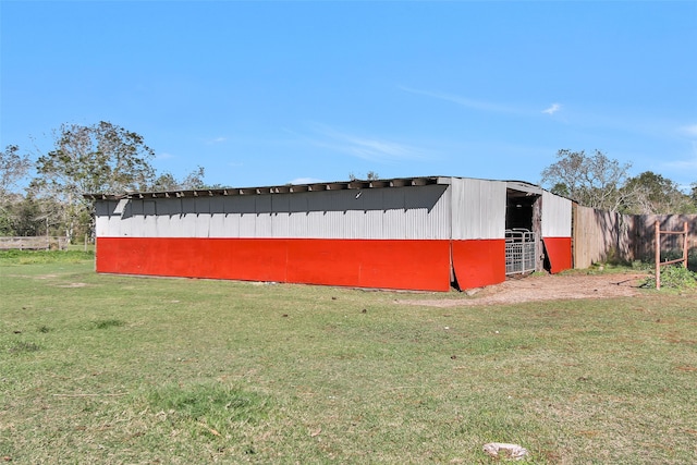 view of side of home featuring a lawn and an outbuilding