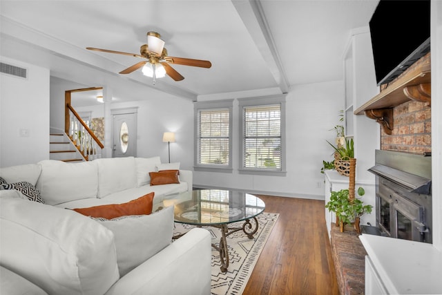 living room with beam ceiling, dark hardwood / wood-style flooring, and ceiling fan