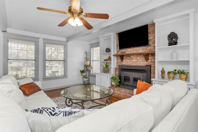 living room featuring ceiling fan, a fireplace, hardwood / wood-style floors, and plenty of natural light