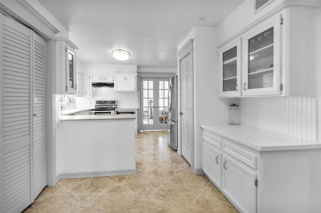 kitchen with french doors, white cabinets, sink, kitchen peninsula, and stainless steel appliances