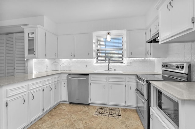 kitchen featuring decorative backsplash, appliances with stainless steel finishes, ventilation hood, sink, and white cabinetry