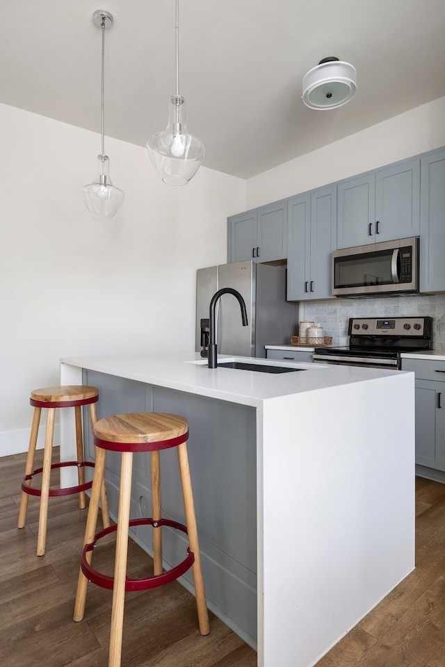 kitchen with decorative backsplash, dark wood-type flooring, stainless steel appliances, and sink