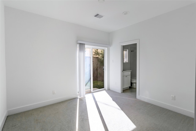 unfurnished bedroom featuring access to outside, ensuite bathroom, and light colored carpet